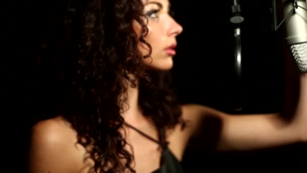 Ung vacker flicka på en studio stroke mikrofon — Stockvideo