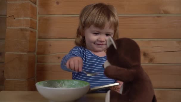 4K små barn utfodring sked Nalle och sig själv — Stockvideo