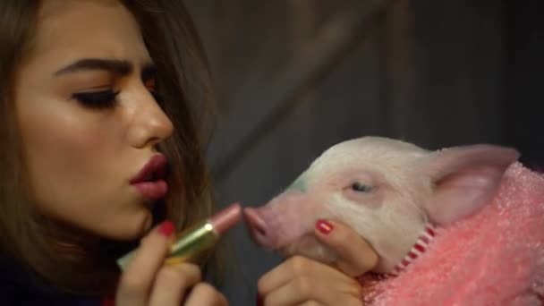 4K belle fille avec maquillage peint les lèvres pour porc et l'embrasse doucement — Video