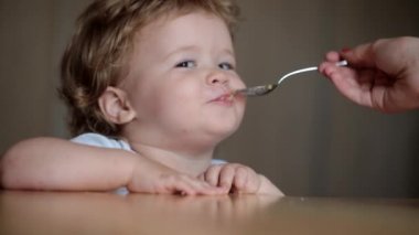 Masada, bir kaşıkla besleme katı gıdalar yemeye çocuk şirin bebek