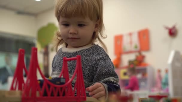 4K Діяльність в дитячому садку, дитина грає з дерев'яною іграшковою дорогою — стокове відео