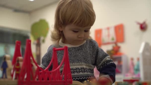 4K lindo chico felizmente jugado con coches de juguete en la habitación de los niños — Vídeo de stock