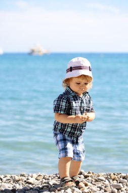 Çakıl plajı üzerinde erkek bebek
