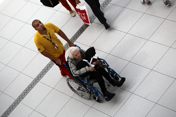 Homem empurrando cadeira de rodas com mulher — Fotografia de Stock