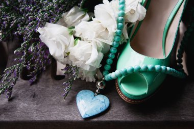 green female shoes, flowers and necklace