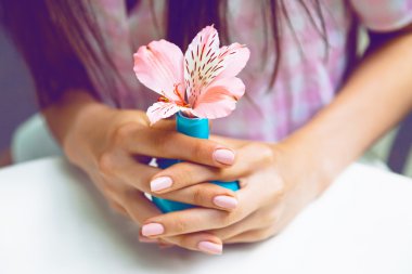 Woman holding small vase with flower