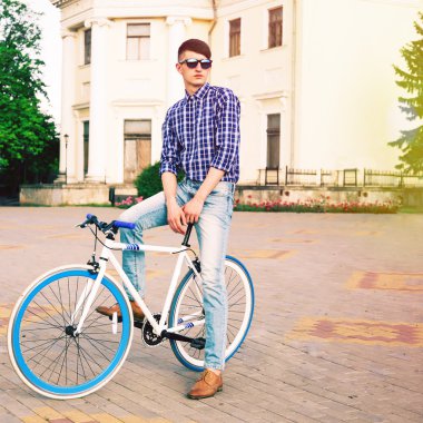 hipster man posing on blue bike