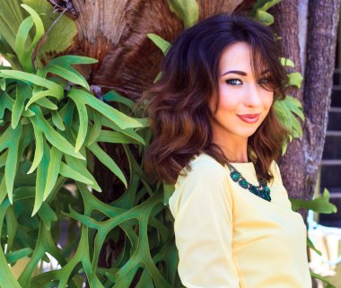 brunette woman posing at exotic garden