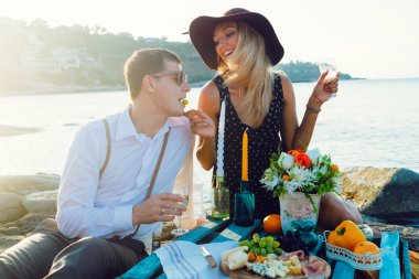 couple enjoying picnic on the beach together