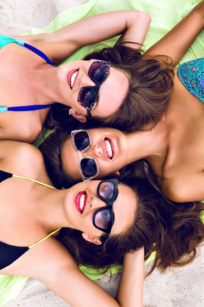 Three girls laying on the beach — Zdjęcie stockowe