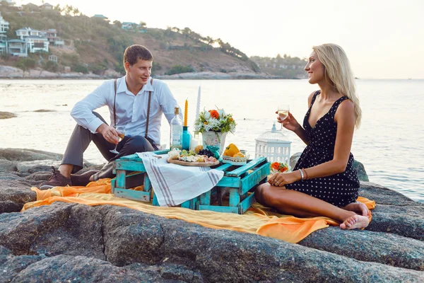Couple enjoying picnic on the beach together — Stockfoto