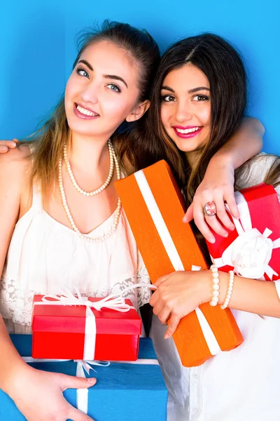 Two sisters holding a lot of presents. — Stock Photo, Image