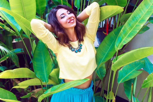 Mulher posando no parque com plantas exóticas — Fotografia de Stock