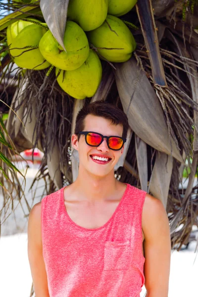 Man posing near palm tree with coconuts — ストック写真