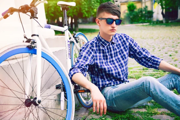 Hipster homem sentado na grama — Fotografia de Stock