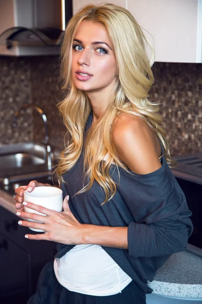 Mujer bebiendo café en la cocina — Foto de Stock