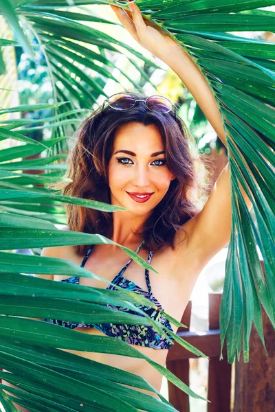 Brunette woman posing at palms garden — Stock fotografie