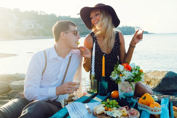 Casal desfrutando de piquenique na praia juntos — Fotografia de Stock