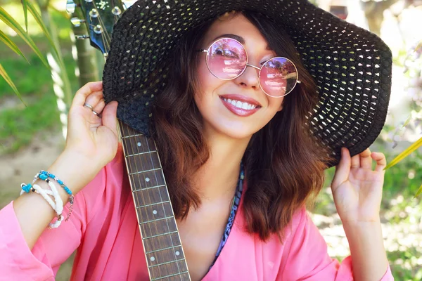 Frau posiert mit Gitarre im Garten — Stockfoto