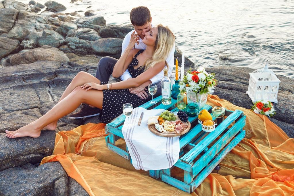 couple enjoying picnic on the beach together