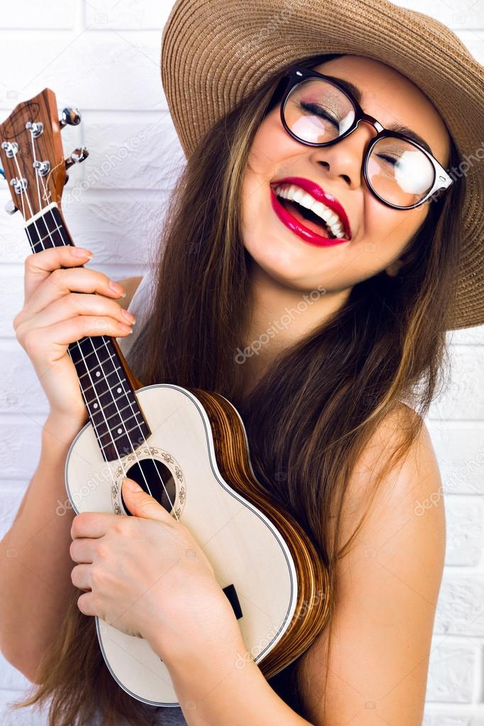 hipster girl playing on small guitar