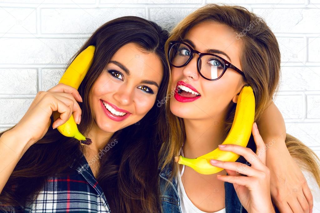 girls playing with bananas imitating telephone