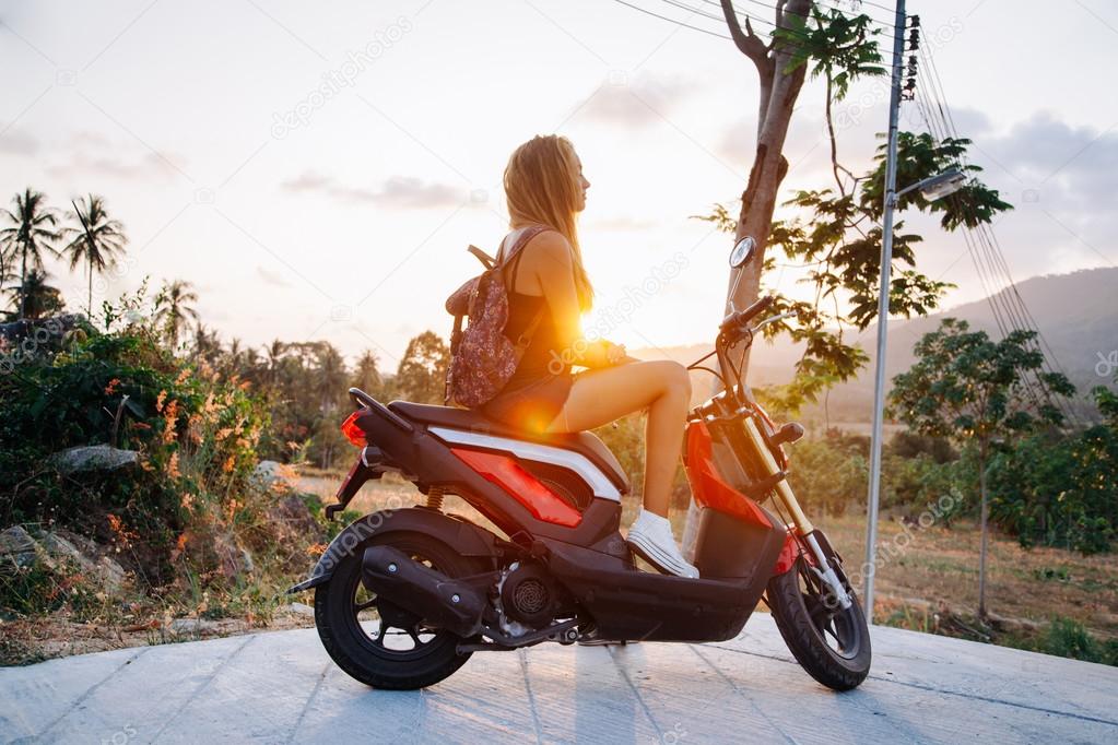 woman posing at red scooter bike