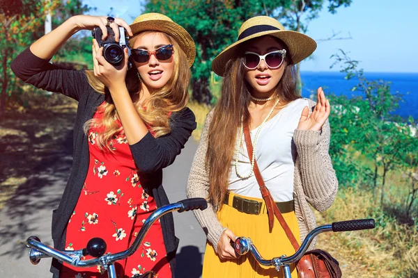 Két hipster lányok gyaloglás-val retro kerékpár — Stock Fotó