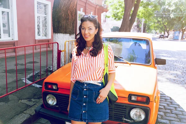 Mulher posando perto de carro retro laranja — Fotografia de Stock