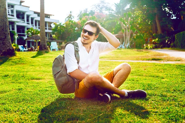 Unga hipster man sitter på gräset — Stockfoto