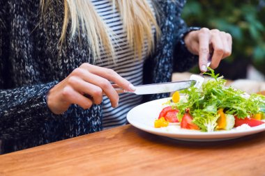 blonde woman eating healthy salad