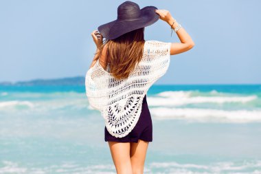 woman posing back near blue sea