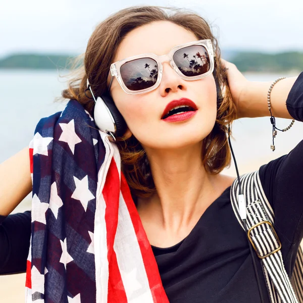 Donna posa in spiaggia ascoltando musica — Foto Stock