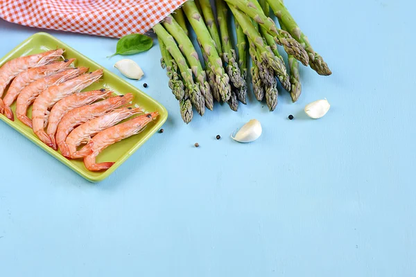 King shrimps in a green rectangular plate on blue background — Stock Photo, Image