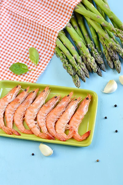 King shrimps in a green rectangular plate on blue background — Stock Photo, Image