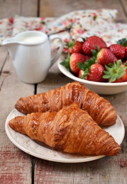 kruvasan beyaz bir tabak içinde taze çilek ile흰색 접시에 신선한 딸기와 크로와상