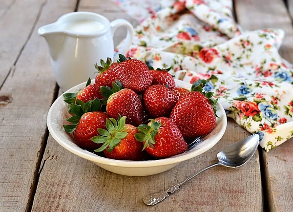 Jordgubbar i en vit platta med mjölk till frukost — Stockfoto