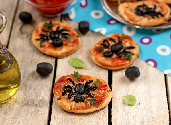 Mini pizzas with olives in shape of spider