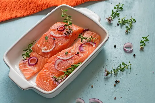 Fresh salmon fillets with onions, pepper and herbs — Stock Photo, Image