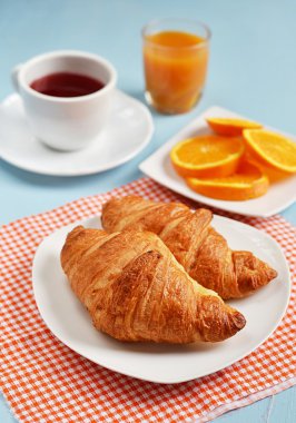 Kruvasan kahvaltı için çay ve portakal suyu ile