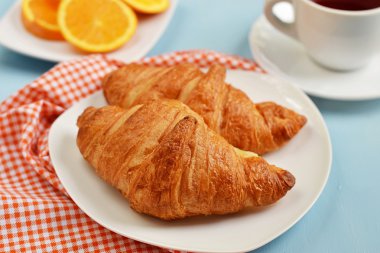 Kruvasan kahvaltı için çay ve portakal suyu ile
