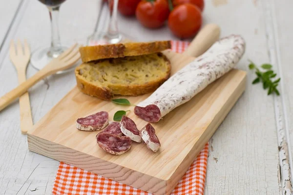 Dried sausage for tapas on the wooden board — Stock Photo, Image