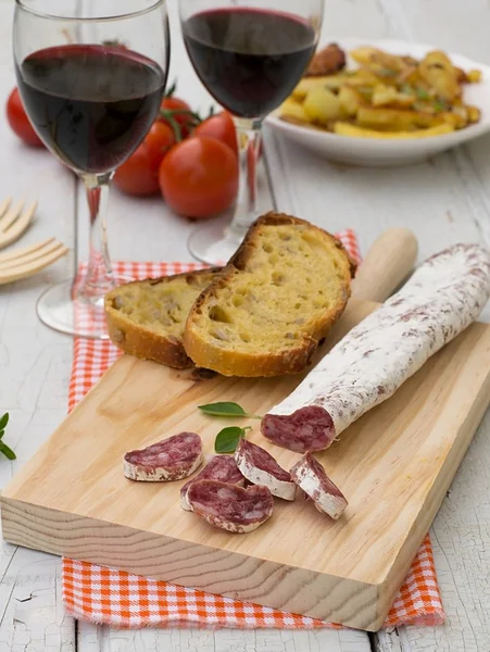 Dried sausage for tapas on the wooden board — Stock Photo, Image