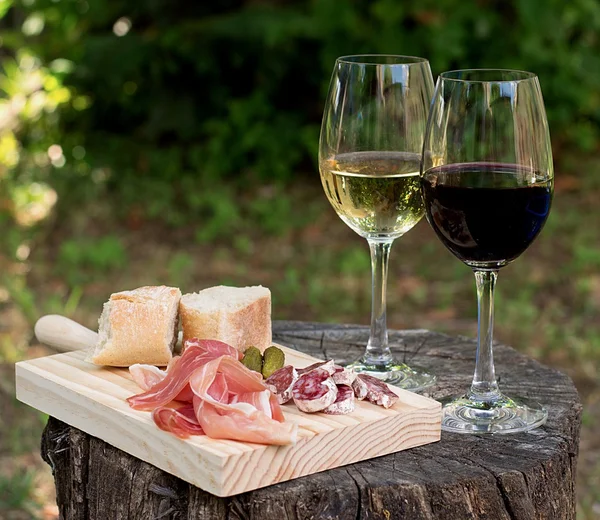 Red and white wine in a glass with sausage and ham — Stock Photo, Image