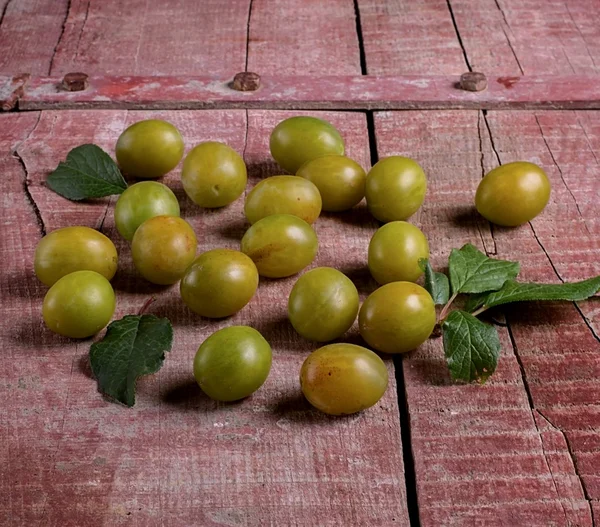 Gele pruimen op een houten tafel — Stockfoto