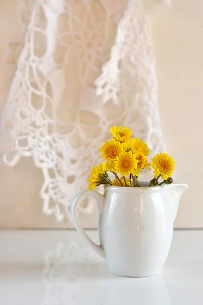 Жовті квіти кульбаби в білому глечику — стокове фото