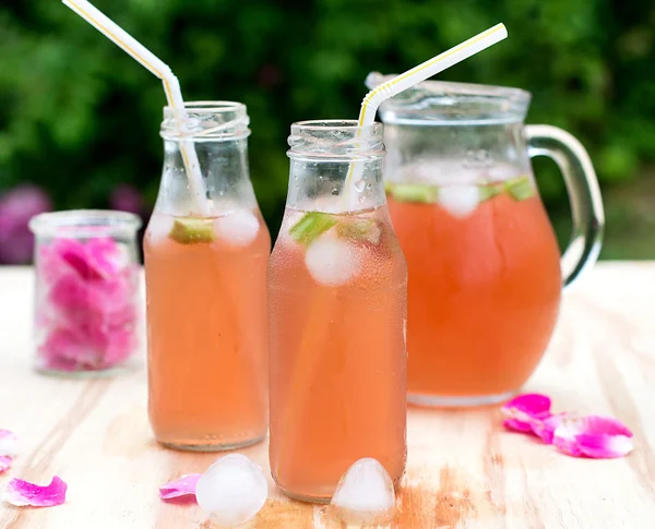 Rhubarb hibiscus iced tea with rose petals in the garden — Stock Photo, Image
