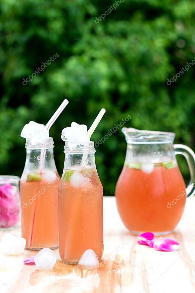 Rhubarb hibiscus iced tea with rose petals in the garden