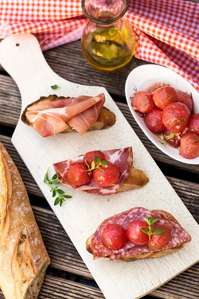 Italian bruschettas with ham prosciutto, coppa and salami — Stock Photo, Image