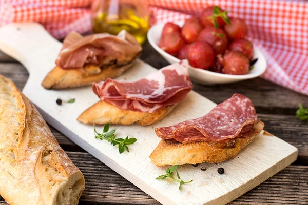 Italian antipasti bruschettas with ham prosciutto, coppa and sal — Stock Photo, Image